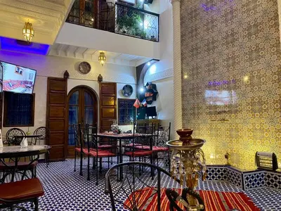 a restaurant with tables and chairs in a room at Riad Lalla Merieme in Marrakech