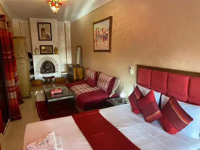 a bedroom with a bed and a living room with a couch at Riad Lalla Merieme in Marrakech