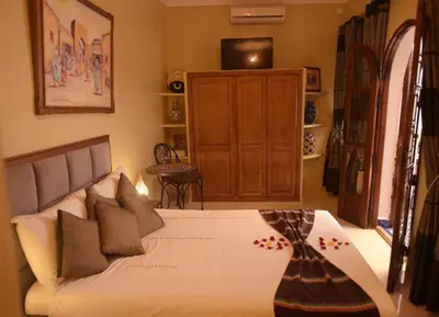 a bedroom with a bed and a television in it at Riad Lalla Merieme in Marrakech