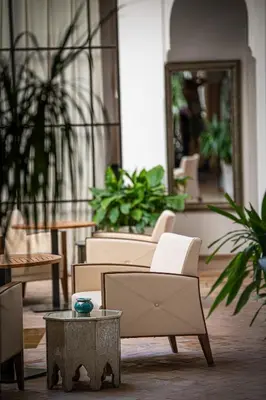 a lobby with chairs and a table and a mirror at Riad Luciano Hotel and Spa in Marrakech