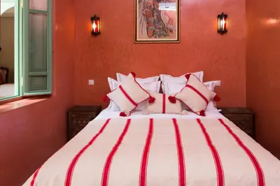 a bedroom with a large bed with red walls at RIAD AZRUR in Marrakech