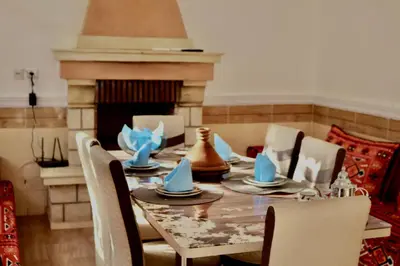 a dining room with a table and a fireplace at Villa Paradis in Marrakech