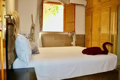 a bedroom with a bed with a swan on it at Villa Paradis in Marrakech