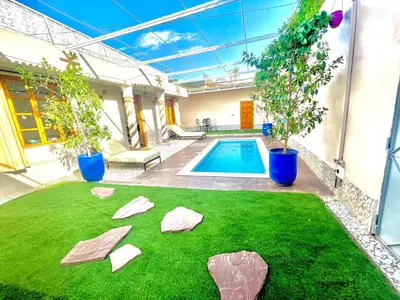 a backyard with a swimming pool with rocks in the grass at Villa Paradis in Marrakech