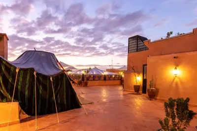 a rooftop patio with a tent in the evening at Riad Medina Art & Suites in Marrakech
