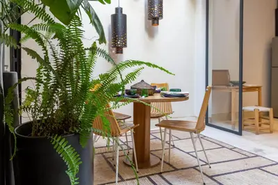 a dining room with a table and a potted plant at Douiria13 in Marrakech