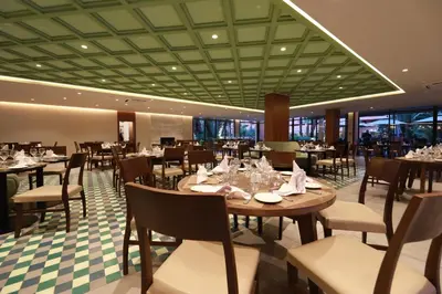 a restaurant with tables and chairs in a room at Kenzi Rose Garden in Marrakech