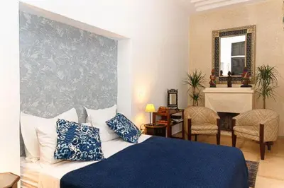 a bedroom with a bed with blue and white pillows at Riad Zouhour in Marrakech