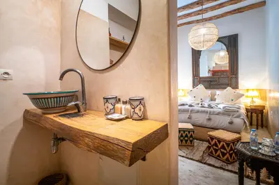 a bathroom with a sink and a bedroom with a bed at Medina Sun in Marrakech
