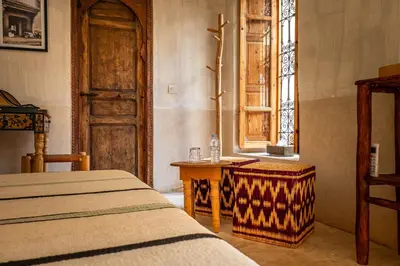 a bedroom with a bed and a table and a window at Medina Sun in Marrakech