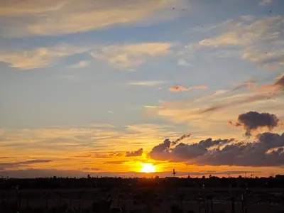 a sunset with the sun setting in the sky at Terrace House in Marrakech