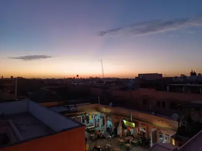 a view of a city with the sunset in the background at Terrace House in Marrakech