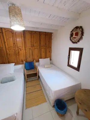 a bedroom with two beds and a table in it at Terrace House in Marrakech