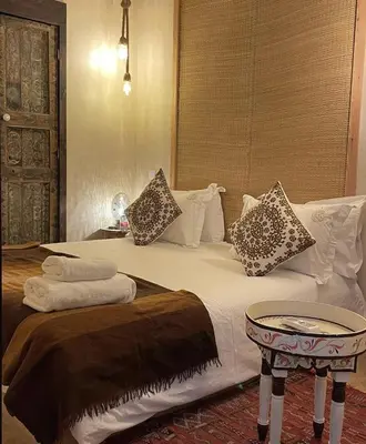 a bedroom with a large bed with a table at Riad Beata Bed & Breakfast in Marrakech