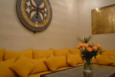 a yellow couch with a vase of flowers on a table at Riad Beata Bed & Breakfast in Marrakech
