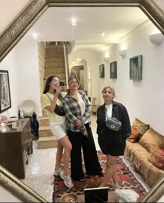 two women standing in a living room taking a picture in a mirror at Riad Beata Bed & Breakfast in Marrakech