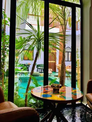a table in a room with a view of a pool at Riad Dar Yasaman in Marrakech
