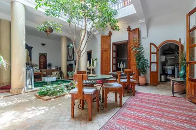a living room with a table and a tree in it at Riad Dar Kasal in Marrakech