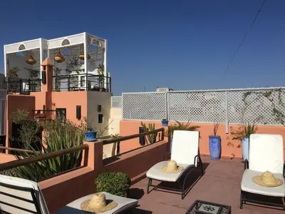 a patio with chairs and a balcony with a building at Riad Dar Kasal in Marrakech