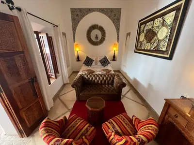 a living room with a couch and chairs and a mirror at Riad Dar Kasal in Marrakech