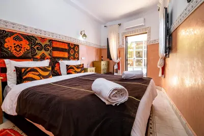 a bedroom with a large bed with a brown blanket at RIAD LA GAZELLE DU SUD in Marrakech