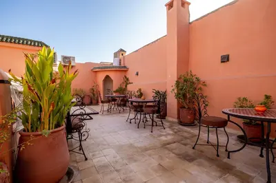 an outdoor patio with tables and chairs and plants at RIAD LA GAZELLE DU SUD in Marrakech