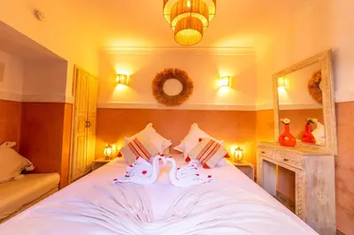 a bedroom with a large white bed with two towels at Riad 7 Saints in Marrakech