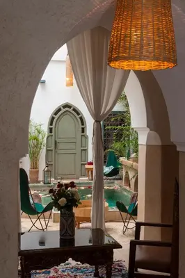 a living room with a table and a pool at Riad La Clé de la Medina, location en exclusivité de tout le riad in Marrakech