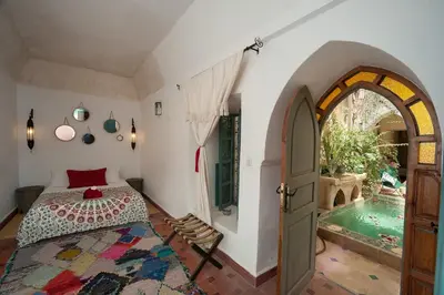 a bedroom with a bed and a swimming pool at Riad La Clé de la Medina, location en exclusivité de tout le riad in Marrakech