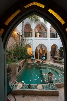 a large swimming pool in a building with an archway at Riad La Clé de la Medina, location en exclusivité de tout le riad in Marrakech