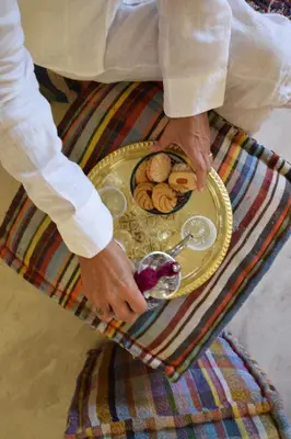 a person holding a plate of food on a table at Miostello Lifestyle Riad Marrakech in Marrakech