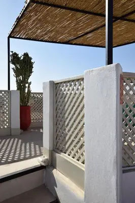 a privacy fence on a balcony with a plant at Miostello Lifestyle Riad Marrakech in Marrakech