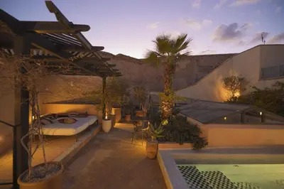 a patio with a bed and a swimming pool at Riad Les Hirondelles Boutique Hotel and Spa in Marrakech