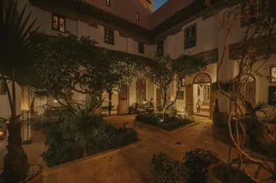 an indoor courtyard with trees and plants in a building at Riad Les Hirondelles Boutique Hotel and Spa in Marrakech
