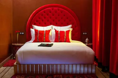 a bedroom with a large bed with a red headboard at Riad Touda in Marrakech