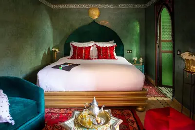 a bedroom with a large bed with red pillows at Riad Touda in Marrakech