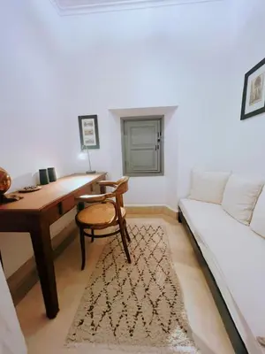 a room with a desk and a couch and a table at Riad Tchaikana in Marrakech