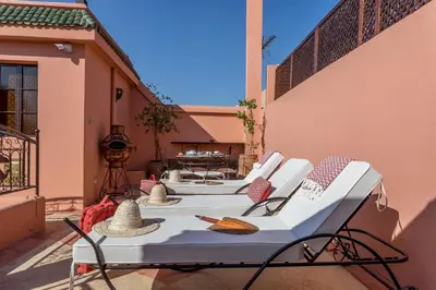 two white chairs and a table on a patio at Riad Hart Essoura in Marrakech