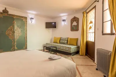 a bedroom with a bed and a couch in a room at Riad Hart Essoura in Marrakech