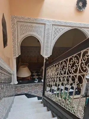 a staircase in a house with ornate white and black tiles at Riad BAB ALMADINA in Marrakech