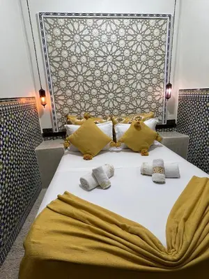 a bed with two pillows and a blanket on it at Dar KHALID in Marrakech