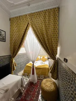 a bedroom with two beds and a window with curtains at Dar KHALID in Marrakech