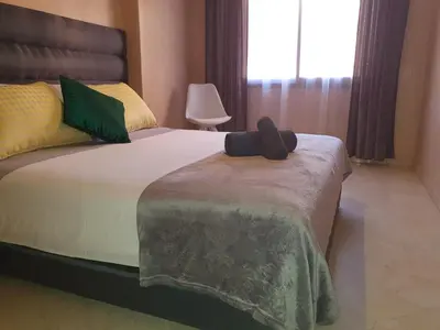 a bedroom with a bed with a black hat on it at Charming Marrakech Apartement in Marrakech