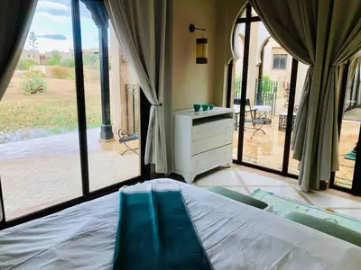 a bedroom with a bed and sliding glass doors at Villa Mayrit, Villa estilo Riad en un entorno único in Marrakech