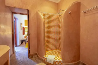a bathroom with a shower with a bench in it at Riad Saba in Marrakech