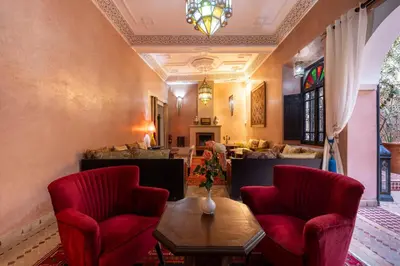 a living room with two red chairs and a table at Riad Saba in Marrakech