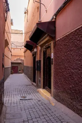 an alley with a brick building and a building with an awning at Riad Saba in Marrakech
