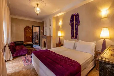 a bedroom with a large bed and a living room at Riad Saba in Marrakech