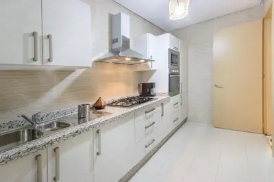 a kitchen with white cabinets and a sink at Pool View With Garden in Prestigia - WIFI & Pool in Marrakech
