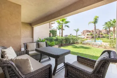 a patio with wicker furniture and a table and chairs at Pool View With Garden in Prestigia - WIFI & Pool in Marrakech